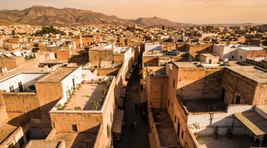 Vue aérienne des ruelles sinueuses d'une médina avec jeux d'ombre et de lumière